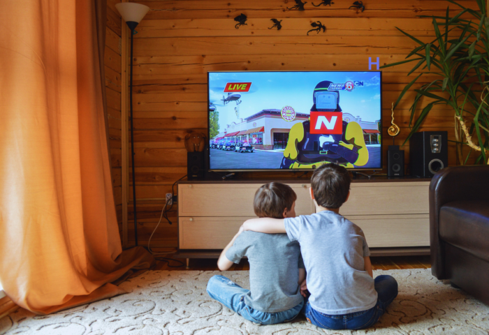 Two children hug while watching television